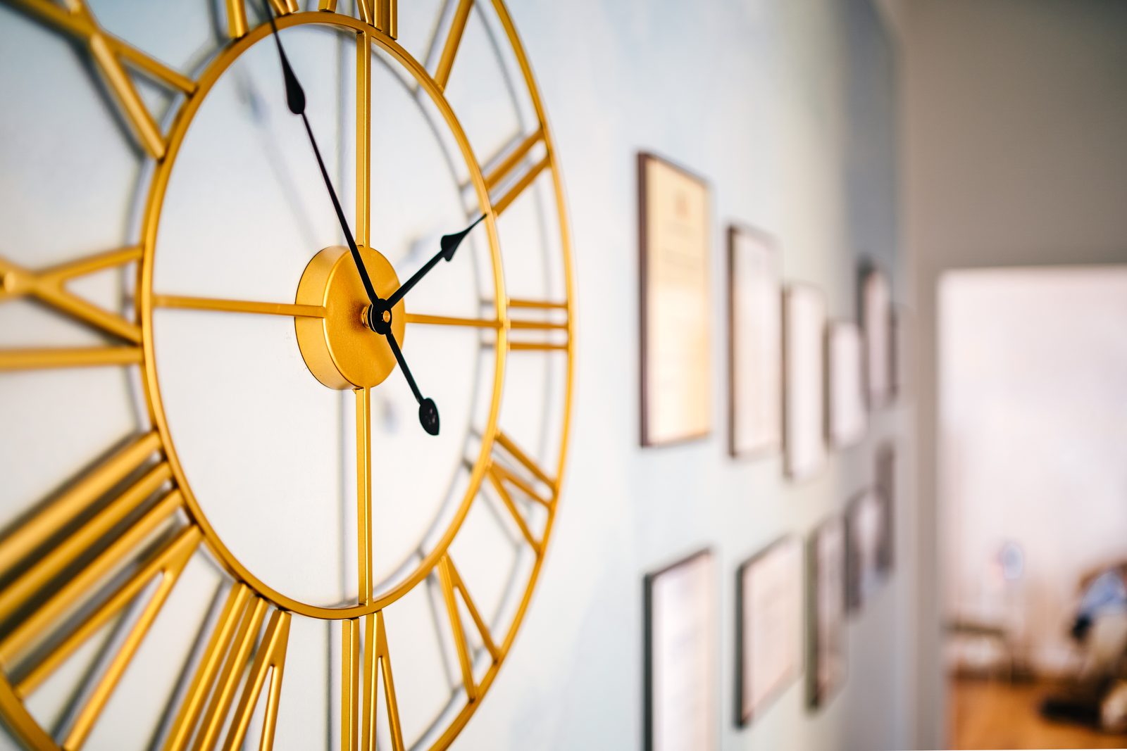 Goldene Wanduhr und gerahmte Fortbildungsnachweise in der Praxis